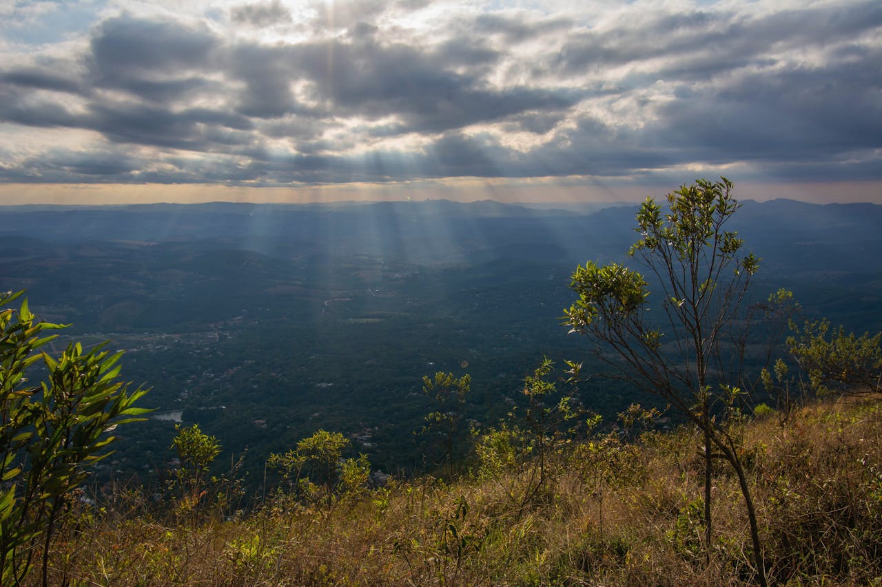 Stunning landscape of Minas Gerais, Brazil with dramatic sun rays piercing through clouds.
