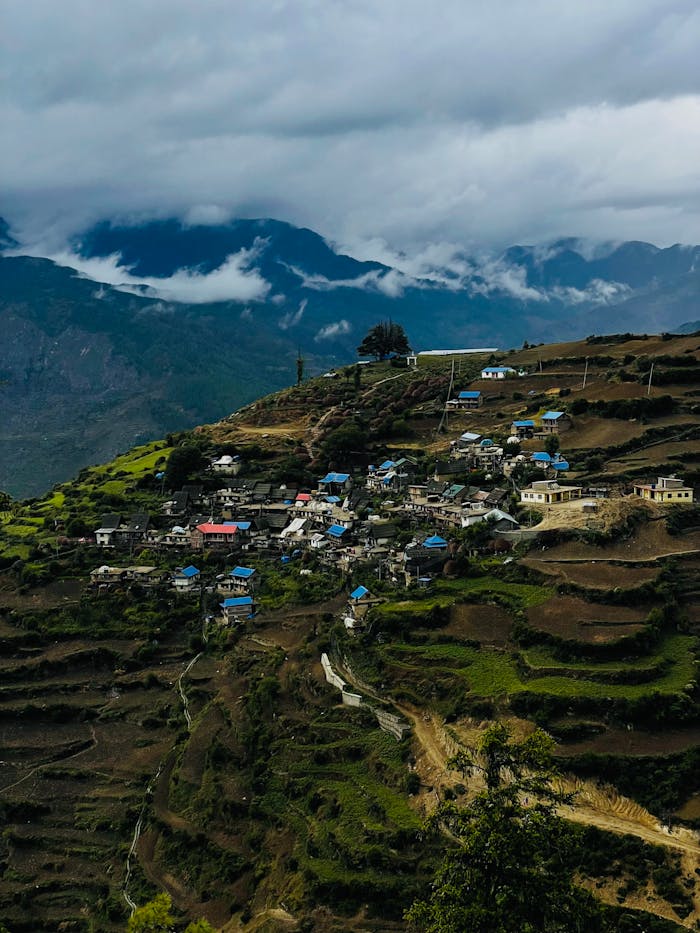 Charming mountain village surrounded by terraced fields and clouds, perfect for travel inspiration.